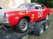 1968 Ford Torino - A red 1968 Ford Torino race car, identified by its body style and decals, is loaded onto a trailer.