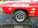 1968 Ford Torino - A close-up view of a red race car's fender displays various sponsor decals, including Holman Moody, STP, Goodyear, and Pennzoil.