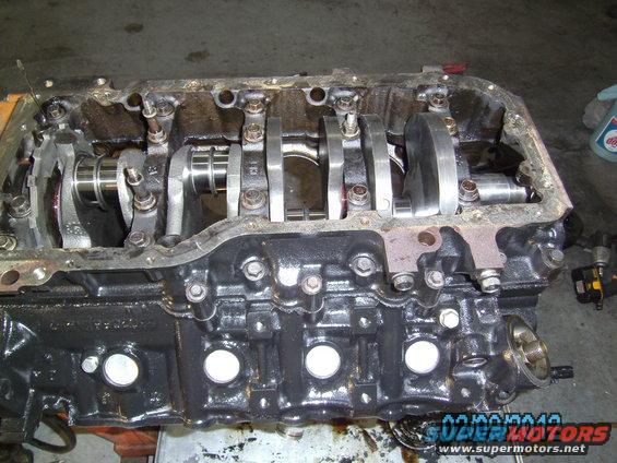 Engine block with crankshaft and connecting rods visible. Oil pan removed