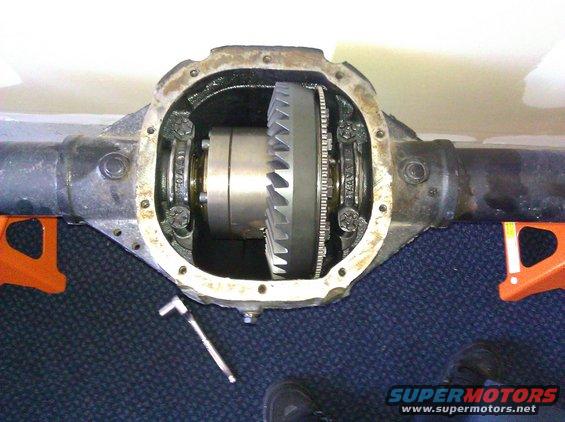 Differential housing with internal gears and a wrench on the floor