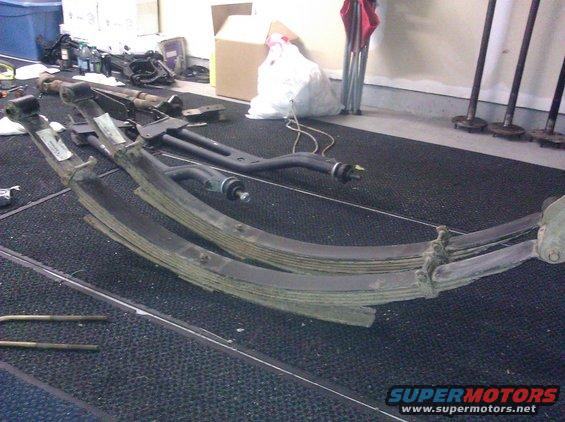 Leaf springs and suspension parts laid out on a black mat