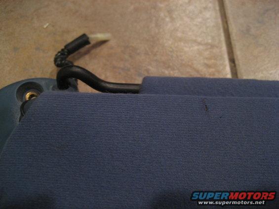Close-up of a blue car sun visor with a black plastic clip and mounting bracket