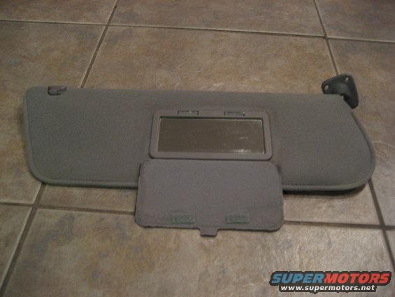 Gray sun visor with vanity mirror and covered compartment