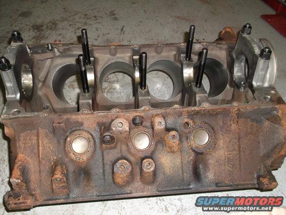 Rusty engine block with connecting rods attached to crankshaft journals
