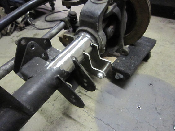 Close-up of a custom axle housing with suspension parts attached, showing welding and mounting brackets