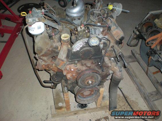 diesel engine with oil filter, fuel lines, and pulleys visible