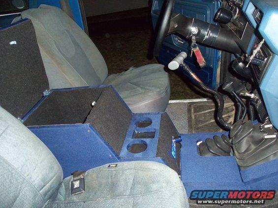 Vehicle interior with custom blue carpeted console, gray seats, and floor shifter