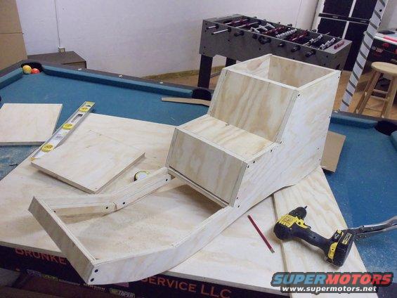 plywood structure on pool table with drill and level
