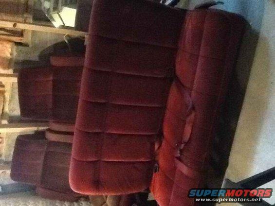 Several rows of maroon velour car seats stacked up