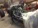 1975 Ford Ranchero - A vehicle chassis is being assembled in a workshop, with parts covered in plastic.