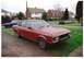 1977 Ford Granada - A red 1977 Ford Granada sedan with a black vinyl roof is parked in front of a house, with another blue car visible in the background.