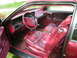 1992 Lincoln Mark VII - The interior of a car features red leather seats, door panels, and a matching steering wheel, accented by wood grain trim.