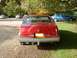 1992 Lincoln Mark VII - The rear of a red Lincoln Mark VII is shown, parked outdoors with other vehicles nearby.
