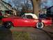 1956 Ford Thunderbird - A classic red 1956 Ford Thunderbird convertible is parked curbside on a sunny day.