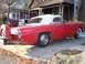 1956 Ford Thunderbird - A red 1956 Ford Thunderbird convertible with a continental kit is parked in a driveway.