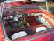 1956 Ford Thunderbird - The interior of a classic red convertible shows wear on the seats and dashboard.