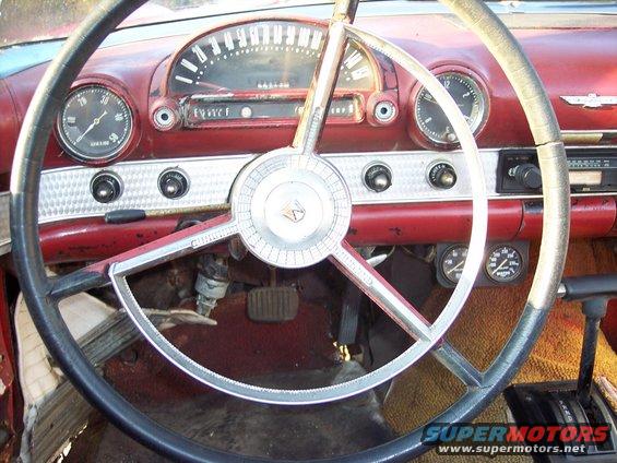 1956 Ford Thunderbird interior dashboard with red trim, large steering wheel, and gauges