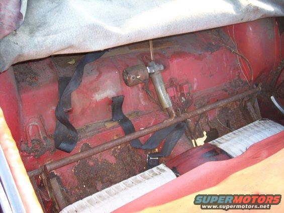 car's rear seat area with seatbelts and rust