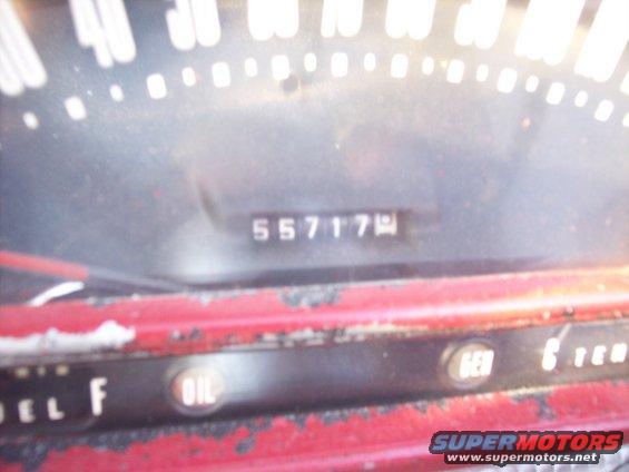 Close-up of a car's dashboard showing the odometer reading 55717 and fuel gauge