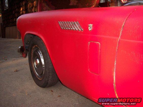 Red 1956 Ford Thunderbird side view with chrome vent and emblem