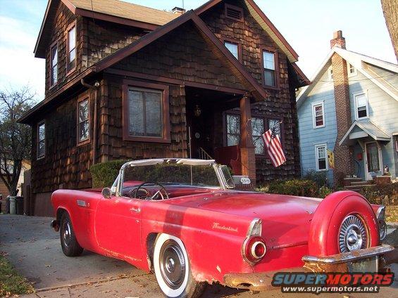 Red 1956 Ford Thunderbird convertible with a continental kit, seen from the rear