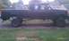 1994 Ford F-250 - Side view of a black pickup truck with a lifted suspension and dual rear wheels.
