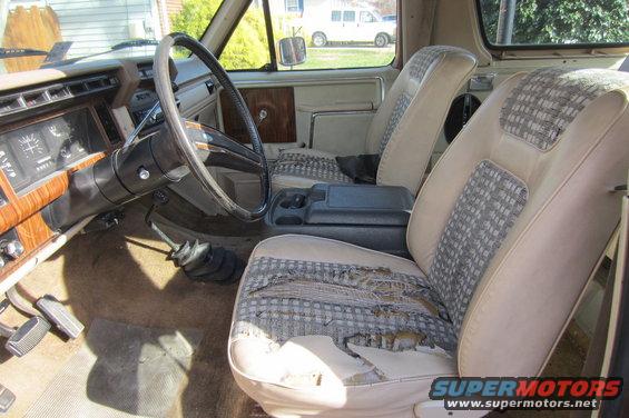 1982 Ford Bronco interior with worn seats and wood grain dashboard