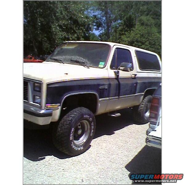 Two-tone SUV with dark blue and tan body panels, lifted suspension, and off-road tires