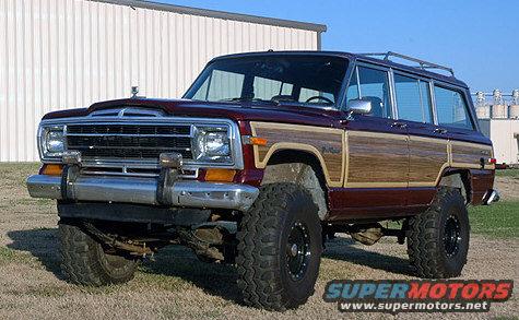 Maroon wood-paneled SUV with large tires, 3/4 front view