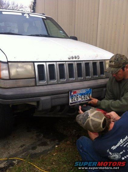 White Jeep Grand Cherokee with a Texas license plate being attached