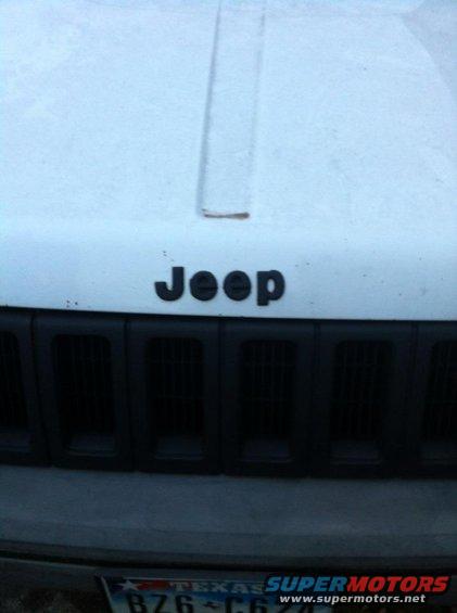 Front of a Jeep with its grille and hood badge visible