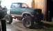 1987 Ford Bronco - This lifted pickup truck features large off-road tires and two-tone green and tan paint.