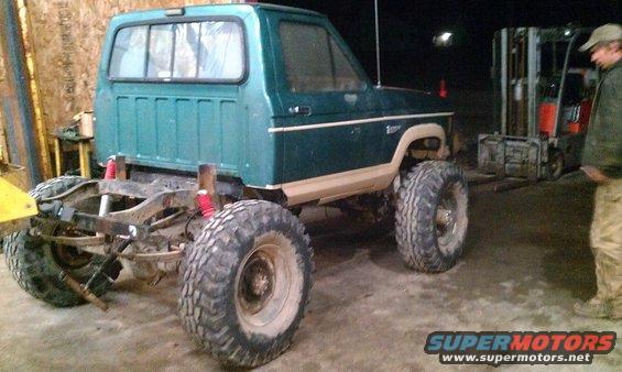 Green pickup truck with large tires, modified frame