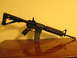 2007 Nissan Titan - A black rifle with a magazine is displayed on a table against a yellow wall.