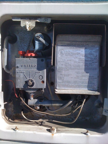 Water heater control with red knobs and a dial labeled 'WARM' to 'HOT'