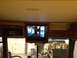 2003 Ford F-350 - The interior of a motorhome shows a mounted television displaying a scene of people walking.