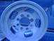 1994 Ford Bronco - A single silver wheel is shown in the bed of a blue pickup truck.