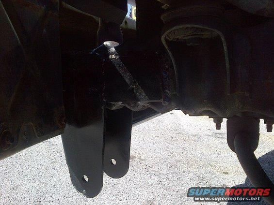 Black painted suspension brackets and frame components with visible bolts and a shock absorber