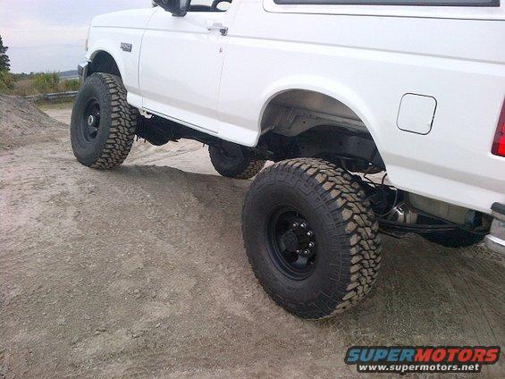 White Ford Bronco, lifted, with large off-road tires, side view