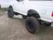 1994 Ford Bronco - This lifted white Ford Bronco features aggressive off-road tires and suspension modifications.
