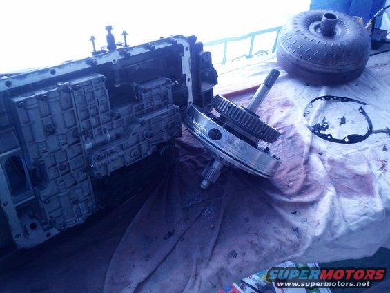 Disassembled transmission case with gears and torque converter on a cloth