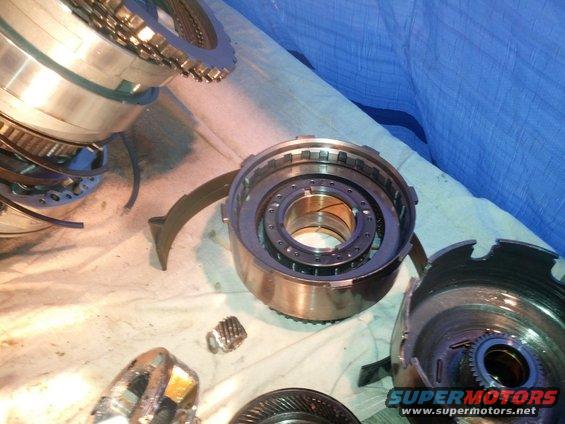 Disassembled transmission parts on a cloth surface. Includes gears and clutch packs