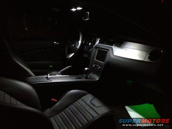 Black leather interior of a 2013 Ford Mustang with illuminated dashboard and center console