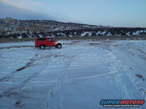 Red and white 1979 Ford Bronco parked in snow