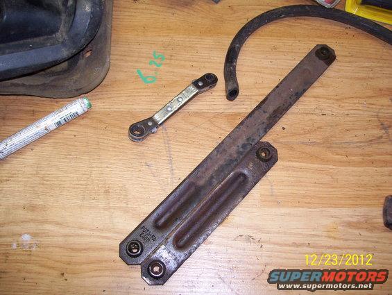Metal bracket with hose and ratchet on wooden surface