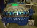 1971 Ford Ranchero - Close-up view of a V8 engine, painted blue with chrome valve covers and a green intake manifold.