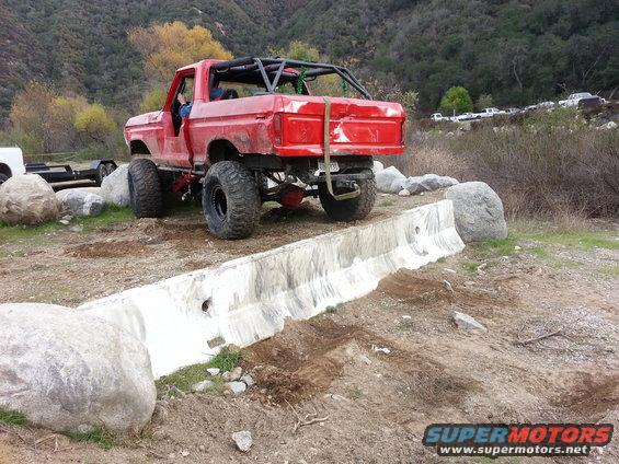 Red lifted pickup truck with roll cage and large tires, 1978 model year