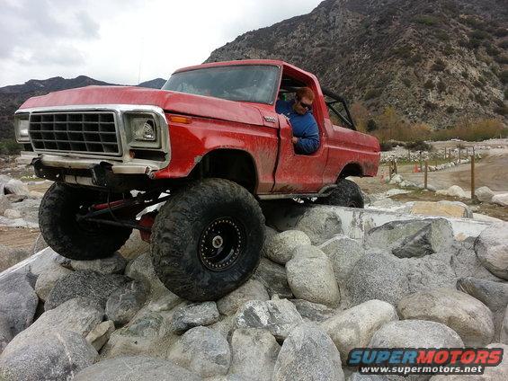 Red 1978 Ford Bronco modified for off-roading on rocks
