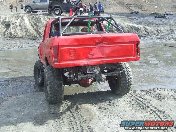 Red 1978 Ford Bronco with roll cage and dual rear wheels