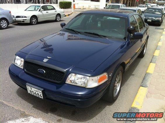Dark blue police car parked on street. License plate reads 85684